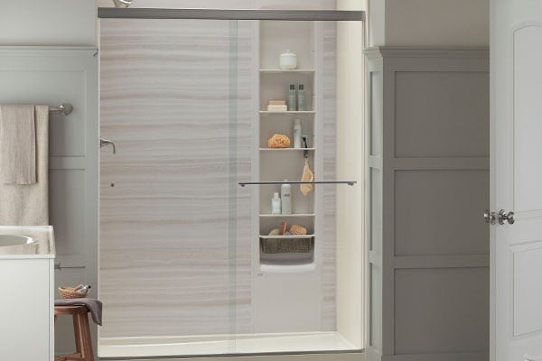 KOHLER LuxStone Shower in Veincut Dune with a sliding glass shower door has a low-threshold step for easy access and plenty of storage for your shower products.