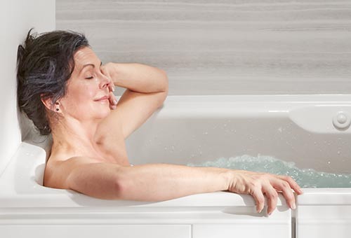 Woman relaxing in Kohler walk in tub