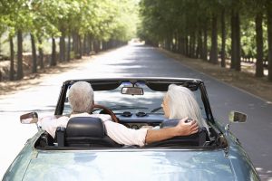 Elderly man and woman driving in car