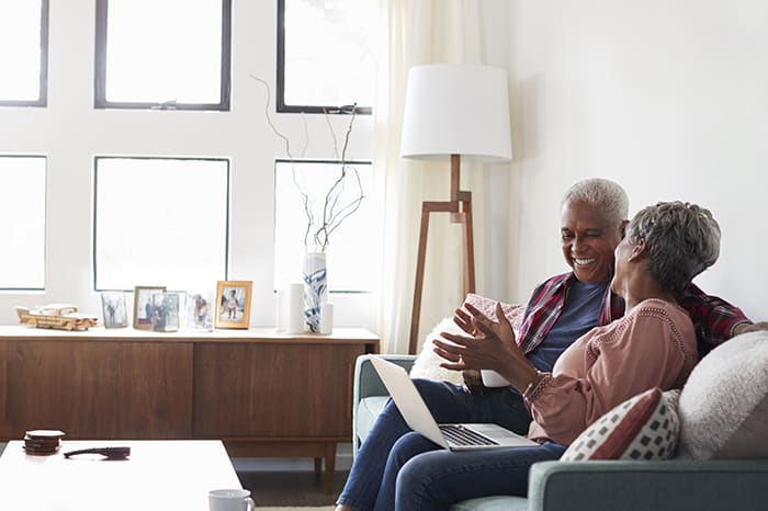 Older adults sit on couch talking