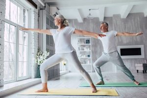 Older man and woman do yoga pose