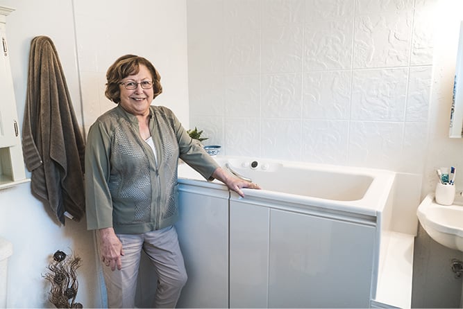 Woman standing next to a walk-in bath