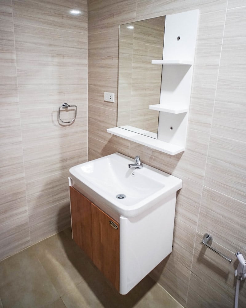 Light veincut pattern bathroom with white and wood sink.