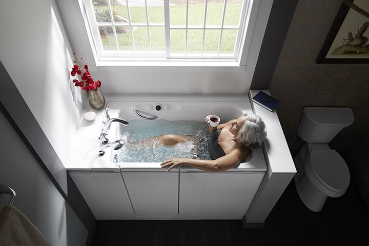 Woman drinking coffee in a walk-in bath