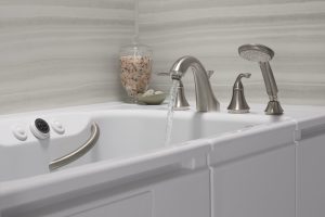 Water running from nickel faucet of walk-in bath