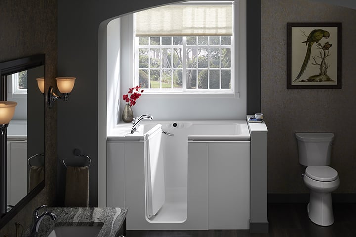 White tub against grey wall with window in background