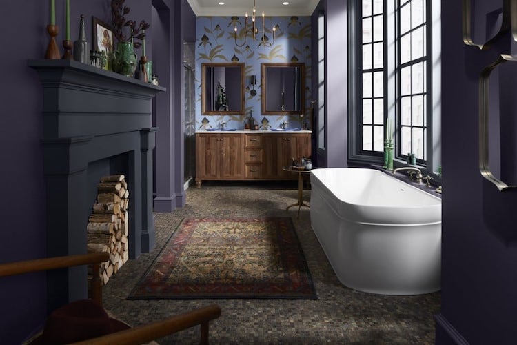 Bathroom with violet painted walls, white tub, and wooden sink