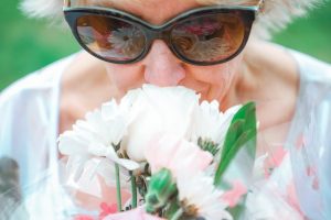 Elderly woman smelling flowers