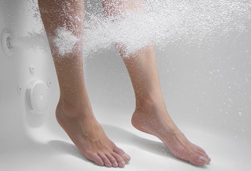 Feet in bathtub with whirlpool jets