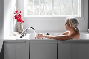 Women feeling water running sitting in bath