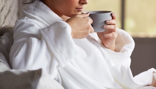 Person in bathrobe drinking warm drink