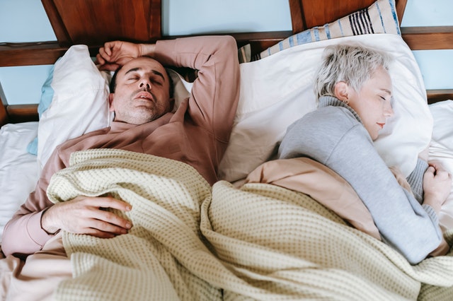 Two people sleeping in bed