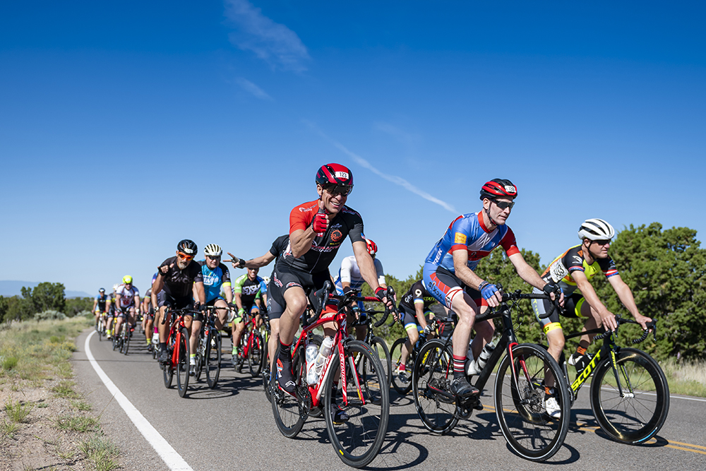 Group of cyclists ride on road