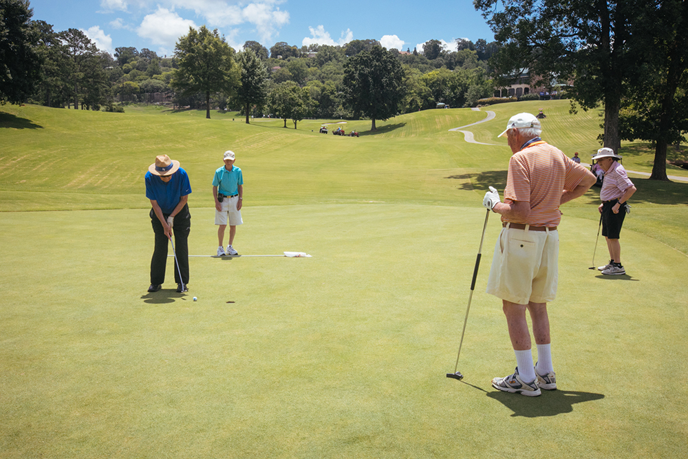 Senior golfers putting on the green.