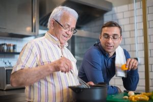 old and young man talking and cooking