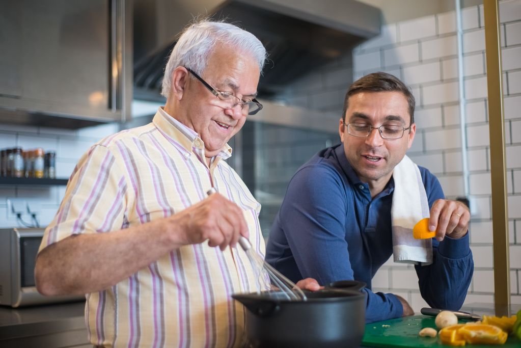 old and young man talking and cooking