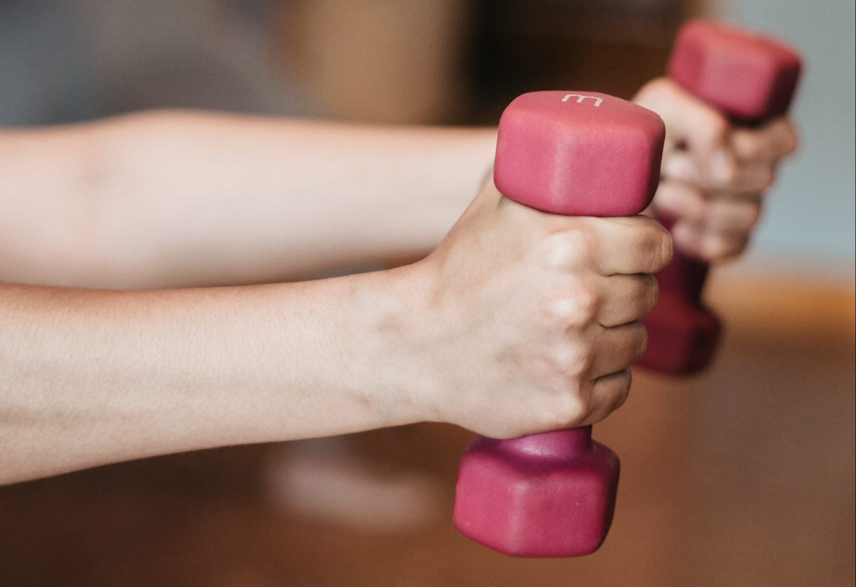 Close-up shot of hands gripping 3 pound dumbells