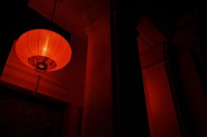 singular red-hued light with a rounded shade surrounding it