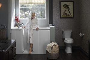 Older woman stepping out of her walk-in tub with her hands on the side of the tub and on the tub door.