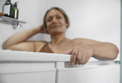 Woman using bath built-in handrails