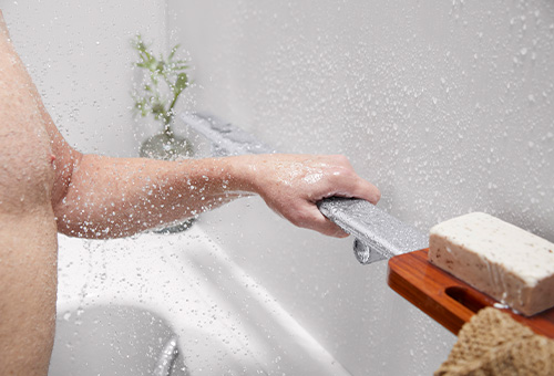 Man holds built-in grab bar in the Walk-In Bath