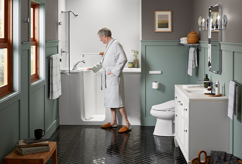 Man opening the extra-wide door of the KOHLER Walk-In Bath